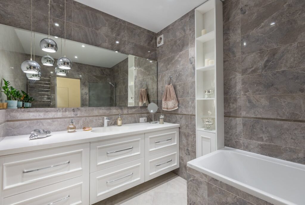 pexels-photo-7166549 Interior of contemporary bathroom with white furniture and bathtub